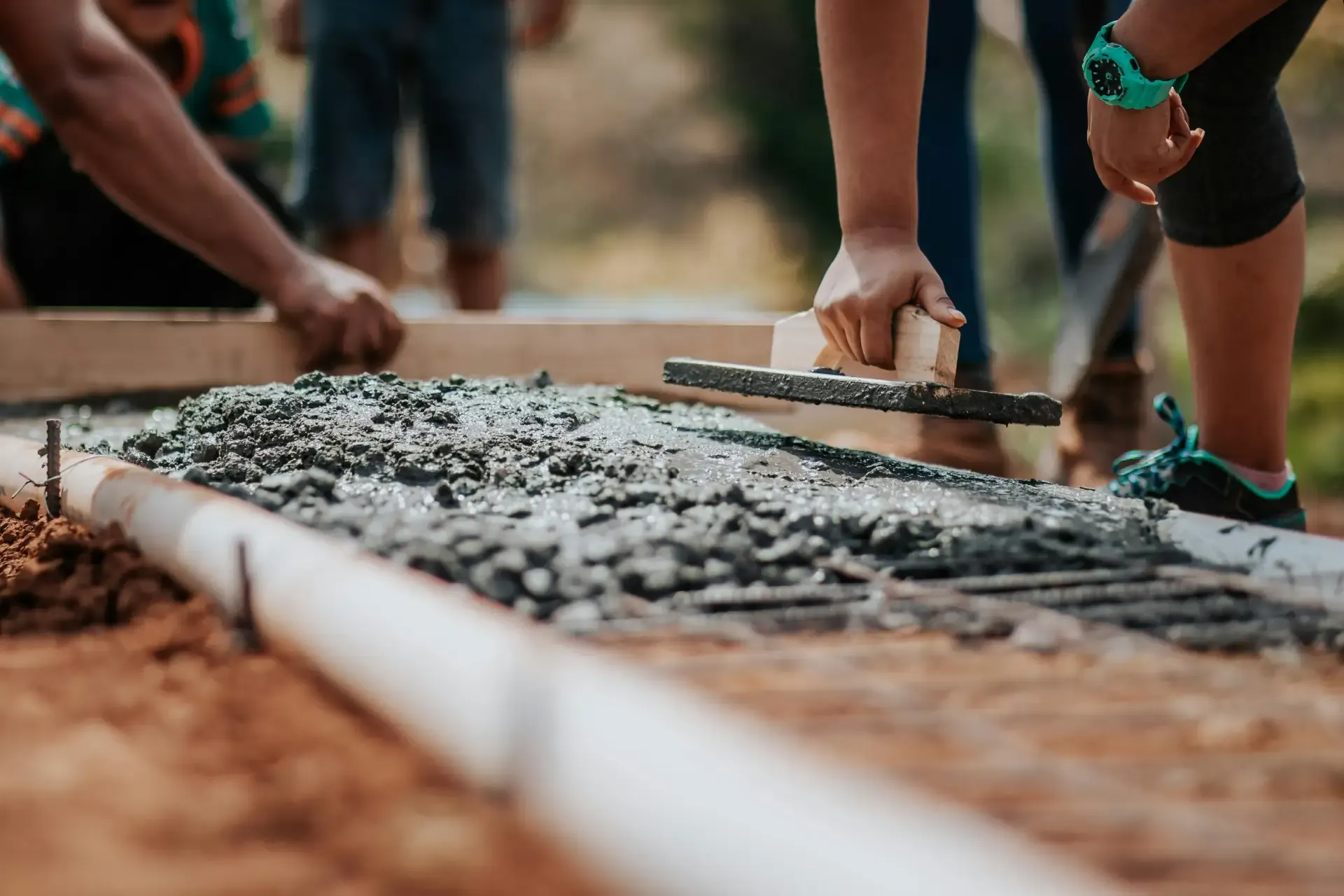 Individuals laying concrete.